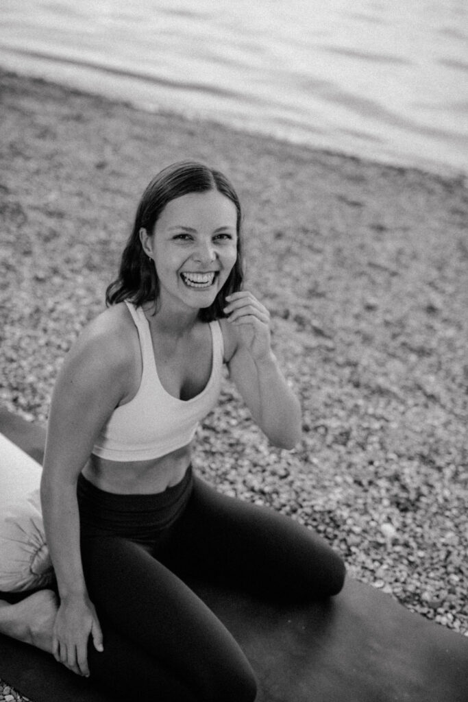 Rebecca sitzt auf einem Bolster und lächelt in die Kamera